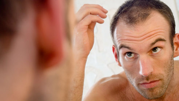 Hombre frente al espejo sufre caída del cabello