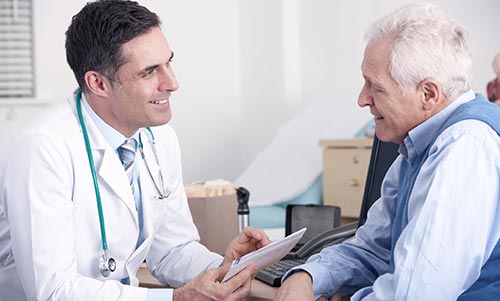 Un doctor atendiendo a un paciente de edad mayor