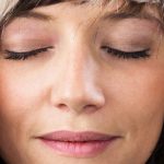Mujer con los ojos cerrados relajada