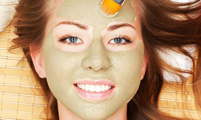 Mujer feliz con máscara facial con arcilla Tierra Madre