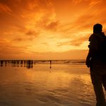Hombre viajero reflexionando mirando al mar