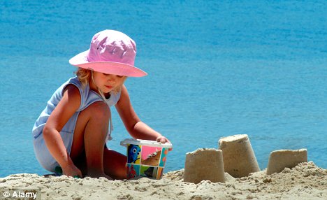 Niña jugando con al arena al sol - padres deben tener precauciones para cuidarlos