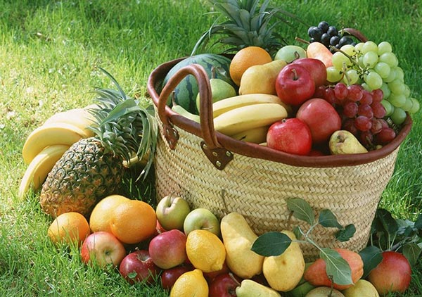 Canasta de frutas saludables en un parque verde
