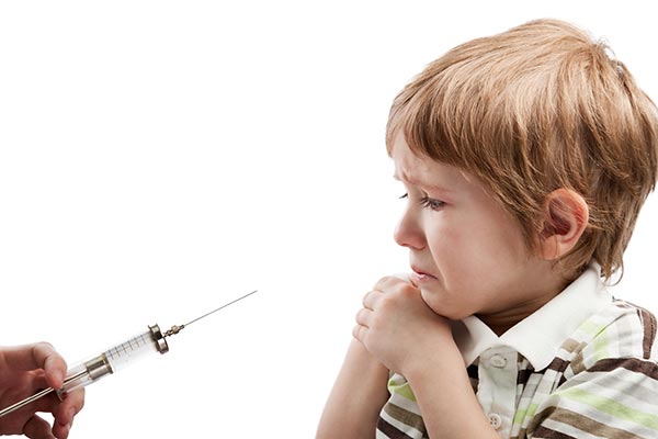 Niño con miedo a que el médico pediatra y a la aplicación de la inyección