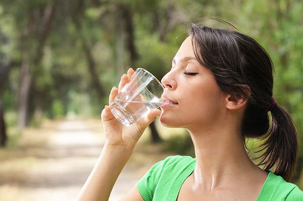 Mujer tomando agua como parte de su alimentación diarioa
